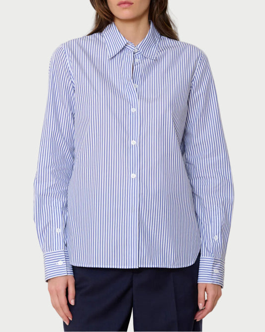 Woman wearing a blue and white striped shirt against a plain background
