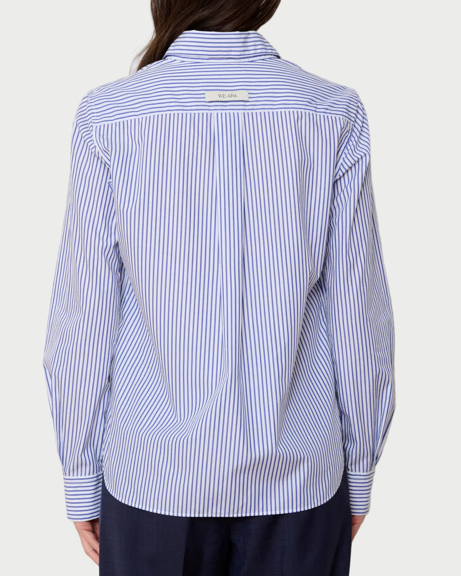 Person wearing a blue and white striped shirt against a plain background