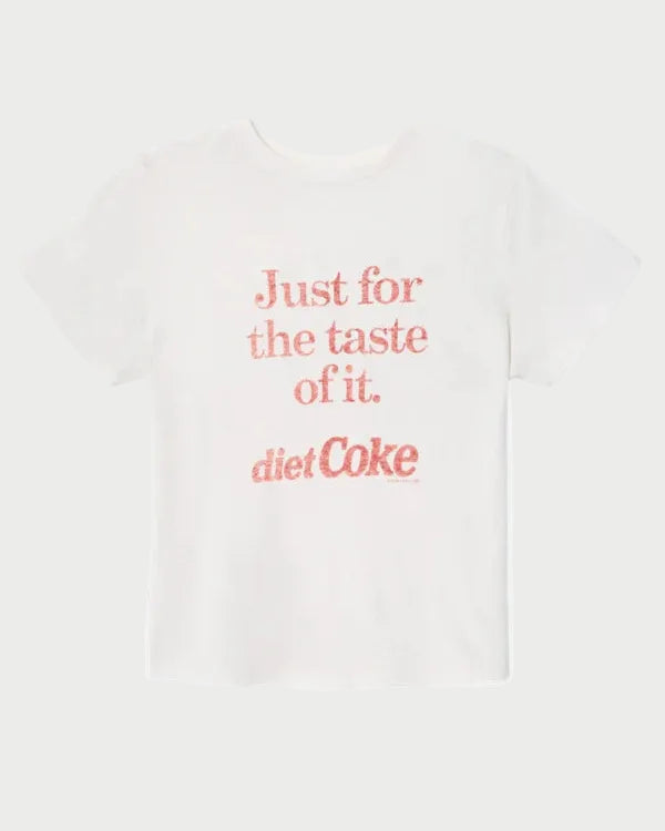 The RE/DONE Diet Coke Classic Tee by RE/DONE is a white t-shirt featuring red text on the front that reads, "Just for the taste of it. diet Coke," displayed against a plain white background. Vintage-inspired and crafted from relaxed fit cotton, this Coca-Cola graphic tee combines casual comfort with classic style.