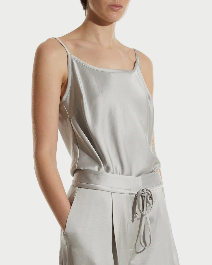 Woman wearing a light gray silk top on a white background