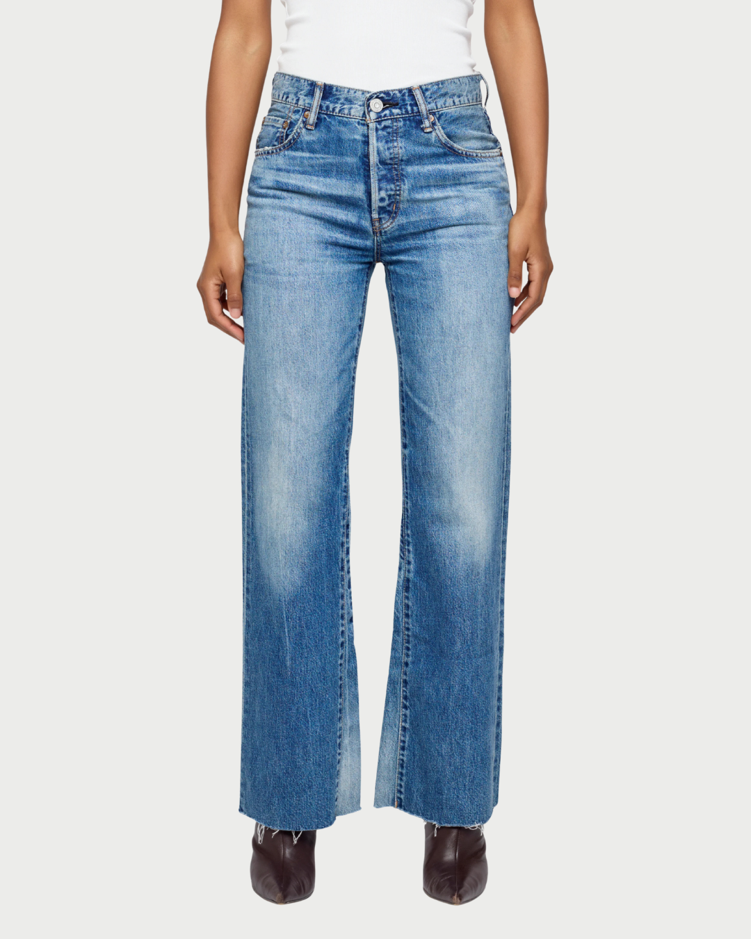 Wearing the Moussy Asheville Flare Jean by Moussy—a high-waisted, wide-leg style crafted from vintage-inspired denim with a faded wash and raw hems—paired with a white top and black boots for effortless style.
