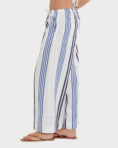 Woman wearing a striped bikini and pants on a white background