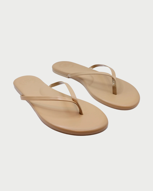 Pair of beige flip-flops on a light gray background