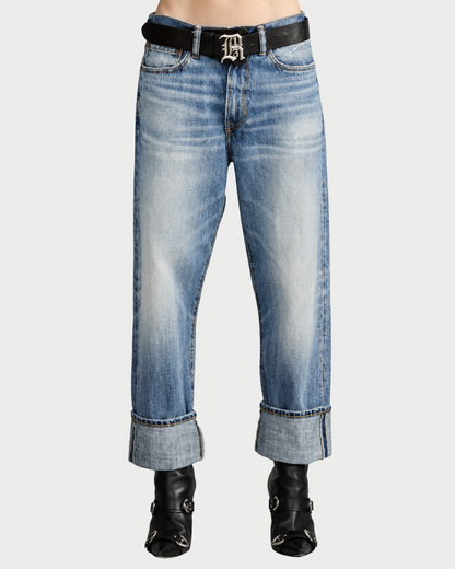 Light wash R13 Cuffed X-BF Jasper Blue selvedge denim jeans with wide cuffs, worn with a black belt featuring a large silver logo buckle and black leather ankle boots.