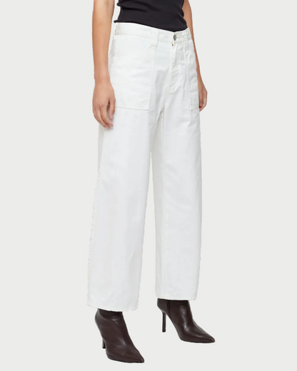 Someone stands against a plain white background wearing Moussy Gusset Cargo Pants by Moussy, paired with a black sleeveless top and black pointed-toe heeled boots.