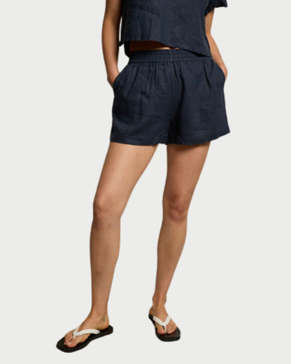 Person wearing navy shorts on a plain background