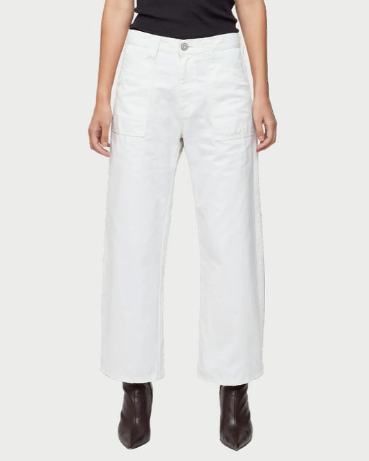 Someone wearing the Moussy Gusset Cargo Pant, a mid-rise, wide-leg white pant with front patch pockets by Moussy, paired with a black top and black heeled boots, shown from the waist down against a white background.