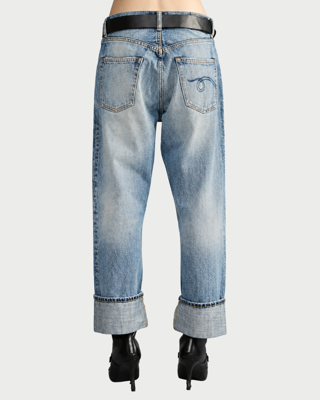 Back view of R13 Cuffed X-BF Jasper Blue jeans in a loose-fit, light-wash style with a wide cuffed hem, a black belt, and a decorative stitch on the right back pocket.