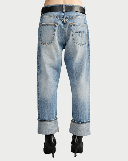 Back view of R13 Cuffed X-BF Jasper Blue jeans in a loose-fit, light-wash style with a wide cuffed hem, a black belt, and a decorative stitch on the right back pocket.