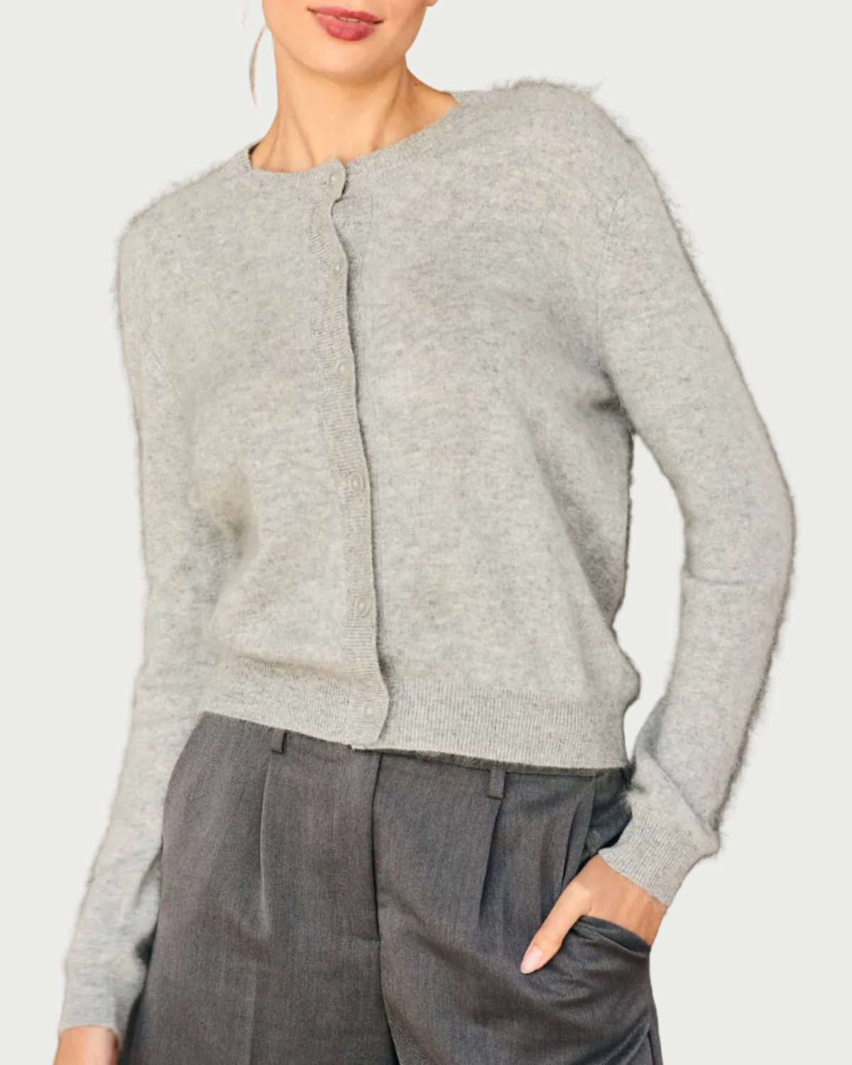 A model wears a JUMPER1234 Brushed Cardigan, an oversized light gray crew-neck button-down with a fuzzy brushed cashmere texture, paired with matching gray trousers.