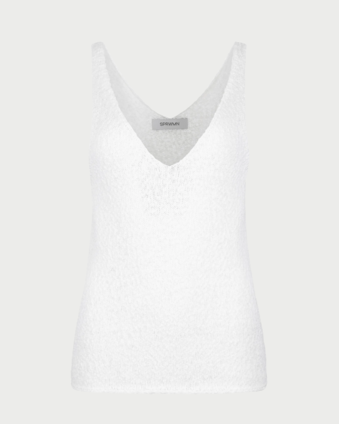 The SPRWMN Camille Top is a white sleeveless cotton bouclé tank with a deep V-neckline, shown on a light gray background. Its textured fabric and neckline label add style, making it a versatile essential by SPRWMN.