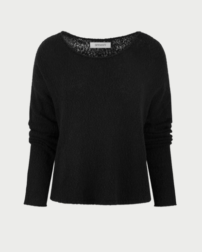 The SPRWMN Off Shoulder Sweater by SPRWMN features a loose fit, plain black cotton bouclé fabric with a slight texture and wide round neckline, shown against a light gray background.