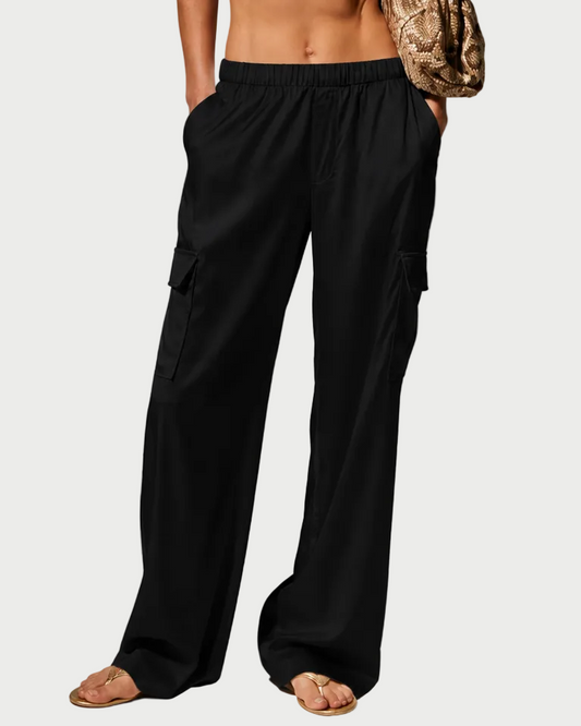 Woman wearing a white halter top and black pants against a gray background