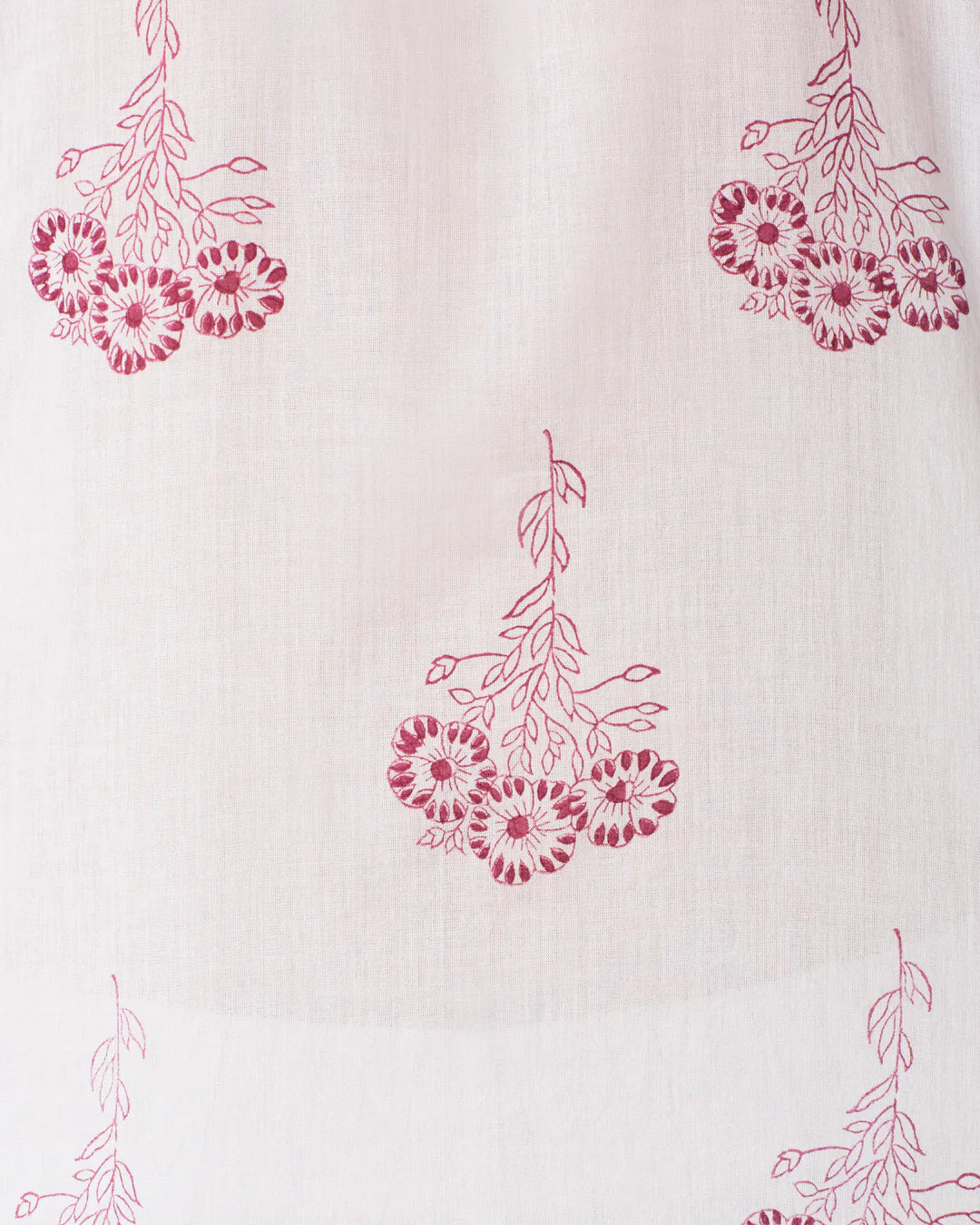 This close-up showcases the Pansy Sky Short Sleeve Shirt by Alix of Bohemia, featuring a vintage-inspired design with red floral clusters on light beige cotton voile. The hand-block printed, intricate petal details form an evenly spaced pattern perfect for stylish wear.