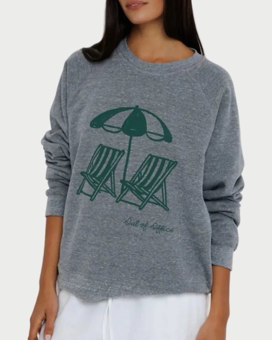 Woman wearing a gray sweater with a graphic design on a white background