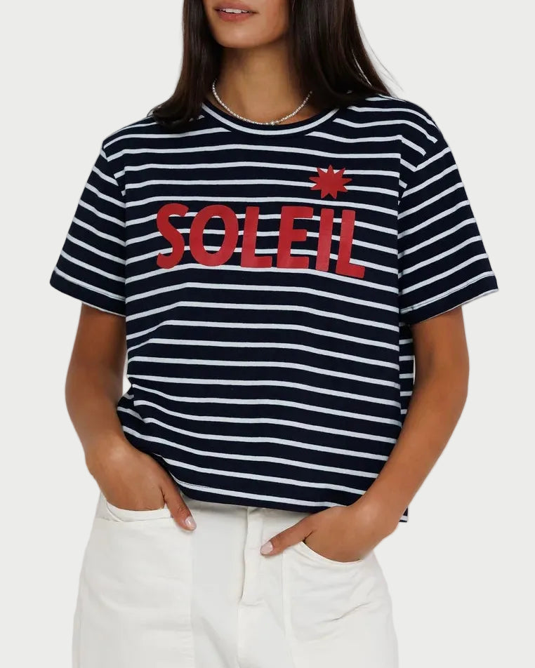 Woman wearing a black and white striped t-shirt with red text on a plain background