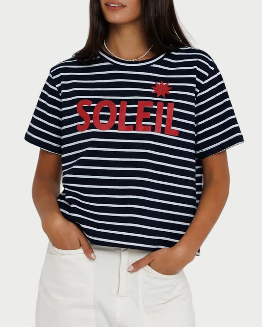 Woman wearing a black and white striped t-shirt with red text on a plain background