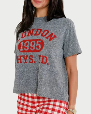 Woman wearing a gray t-shirt with red text and red checkered pants against a white background