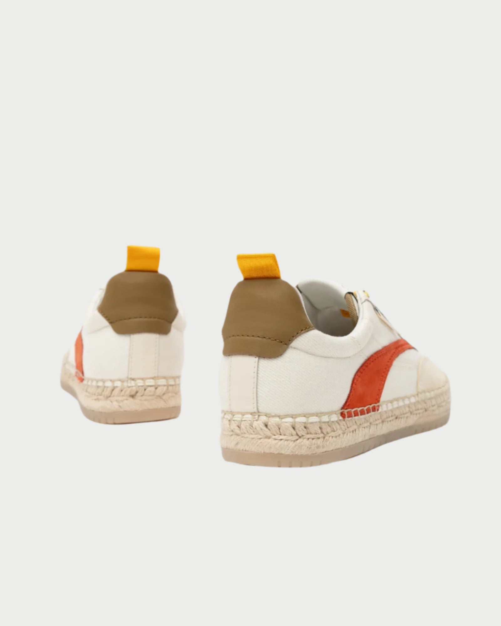 The St Tropez Sneaker by Oncept features brown accents, orange stripes, and yellow heel tabs. Its woven espadrille-style sole blends casual flair with stylish comfort. Photographed from the back on a plain white background, these sneakers highlight their unique design elements.