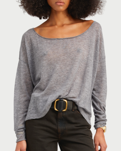 Woman wearing a gray sweater and black pants on a white background