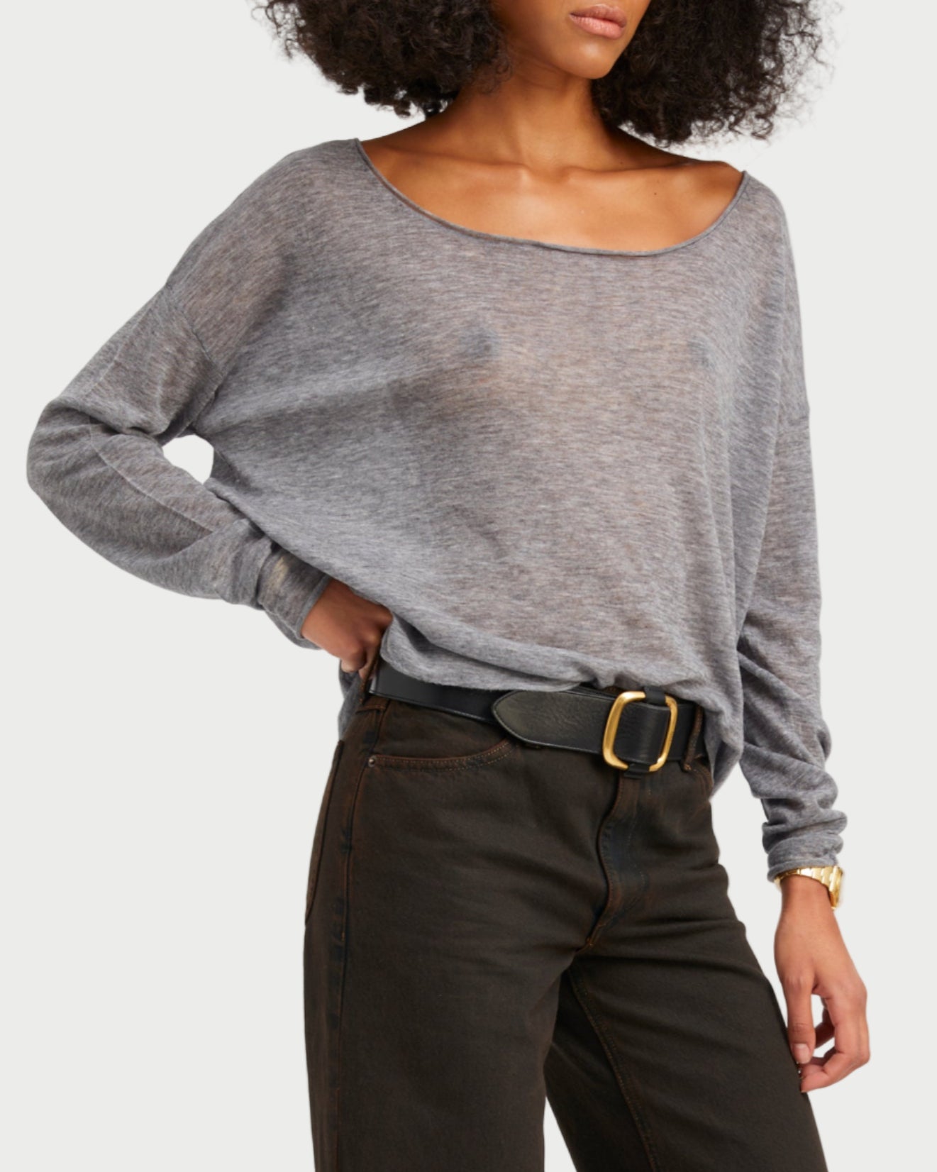 Woman wearing a gray sweater and black pants on a white background