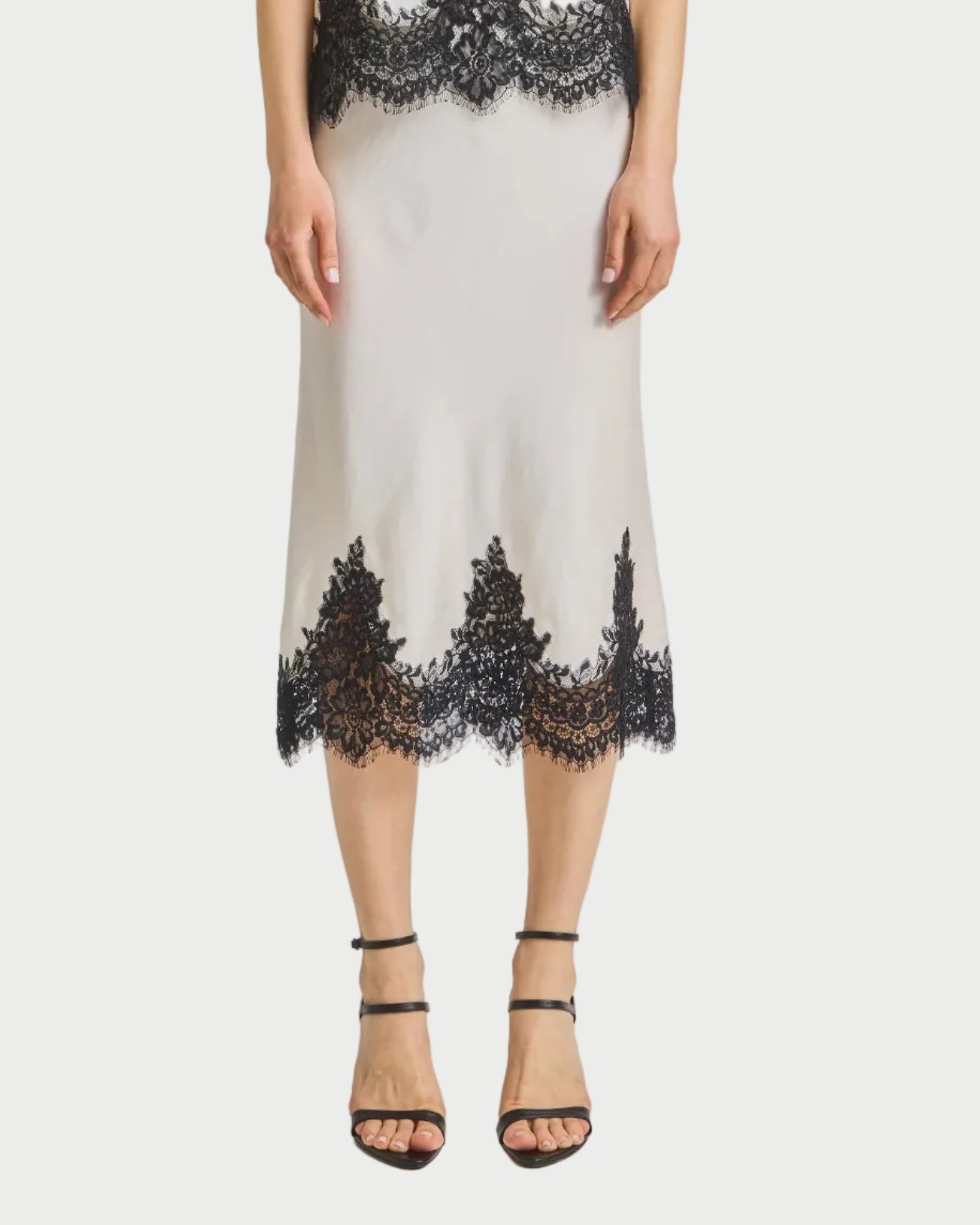 Woman wearing a skirt with black lace details on a white background