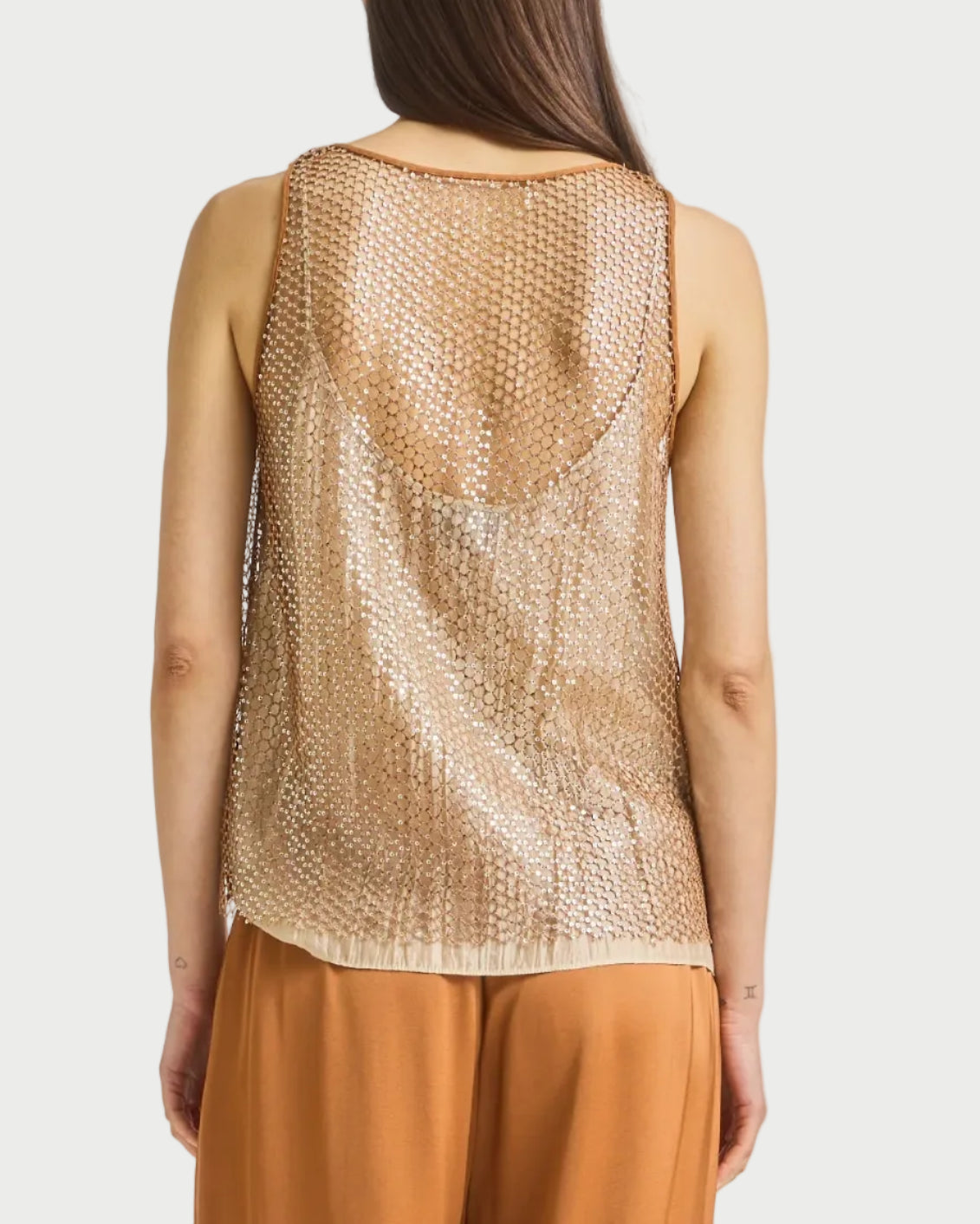 A woman is shown from the back wearing the Saint Art NY Menton Mesh Sequin Top over a nude undershirt and wide-legged light brown pants, with her straight brown hair down.