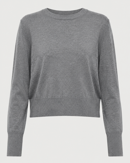 The Saint Art Elodie Sweater by Saint Art NY is a lightweight women’s crew neck sweater in grey, featuring long sleeves with ribbed cuffs and waistband, crafted from soft merino wool and shown against a white background.