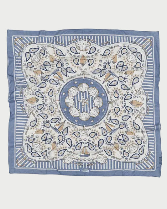 The Maison Lecomte Flament Bretagne Scarf by Maison Lecomte Flament is a square blue and white scarf with a maritime-inspired print featuring seashells, coral, paisley shapes, striped borders, and a central circular shell motif.