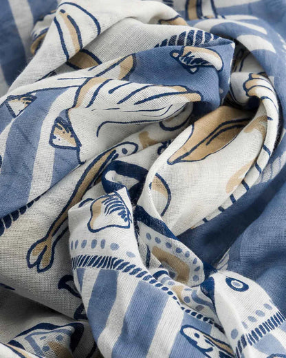 The Maison Lecomte Flament Bretagne Scarf, by Maison Lecomte Flament, is a soft cotton voile scarf featuring artistic blue, white, and beige fish patterns inspired by Bretagne's maritime charm.