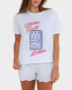 Woman wearing a white t-shirt with graphic design and white shorts on a plain background