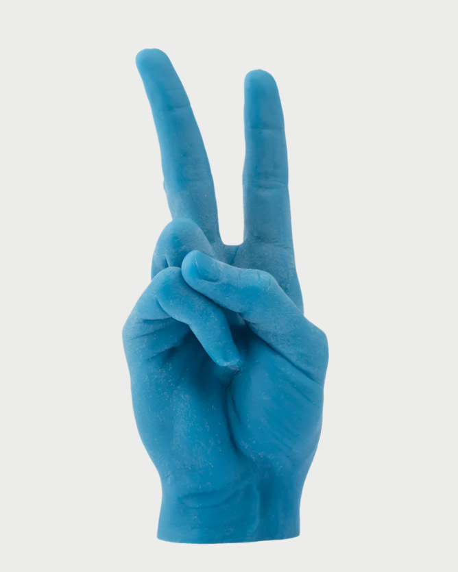 A life-sized, blue wax Candle Hand Victory "Peace" by 54° Celsius shaped like a human hand making a peace sign gesture. This handmade candle has wicks at the tips of the index and middle fingers. The background is solid white, making it perfect for Spring decor.