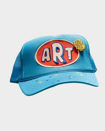 Blue cap with 'ART' logo on a textured surface