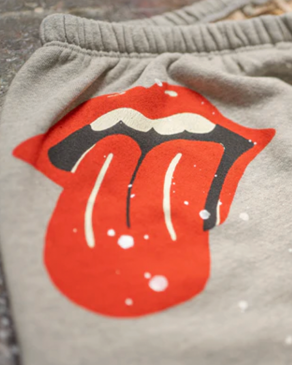 Gray sweatpants with a red and black graphic of a tongue sticking out on a textured surface.