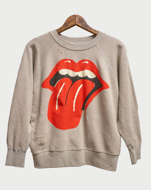 Gray sweatshirt with Rolling Stones tongue logo on a hanger against a rustic background