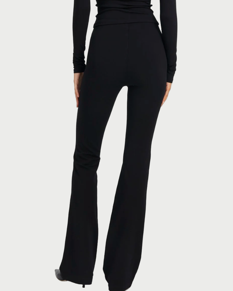 Black flared pants worn by a person on a white background
