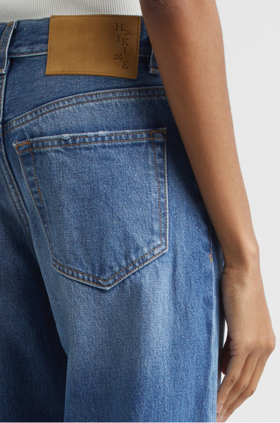 Close-up of blue jeans with a brand label on a white background