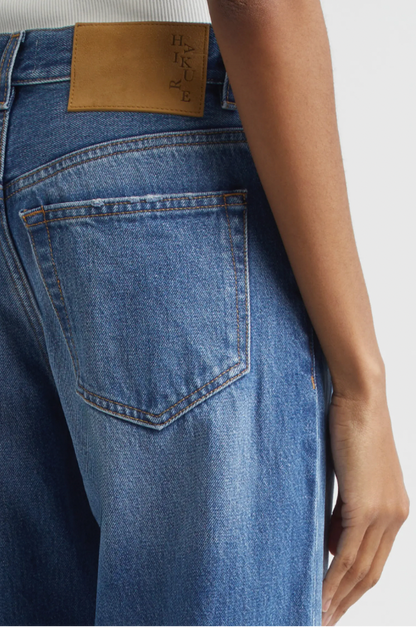 Close-up of blue jeans with a brand label on a white background