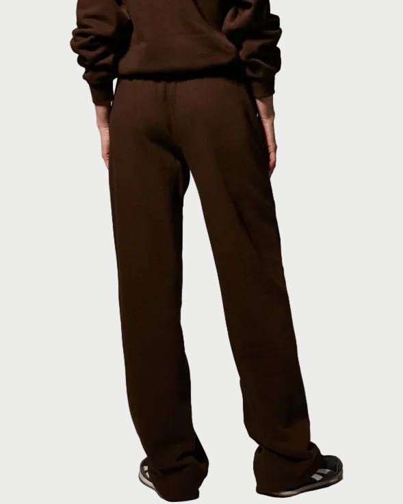 A person is seen from the back wearing SPRWMN Straight Leg Sweatpants in dark brown cotton-fleece, featuring an adjustable drawstring waist, paired with a matching sweatshirt and black sneakers, standing against a light background.
