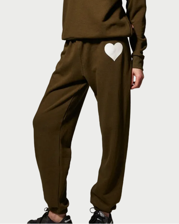Olive green SPRWMN Heart Sweatpants featuring a large white heart graphic on the left hip.