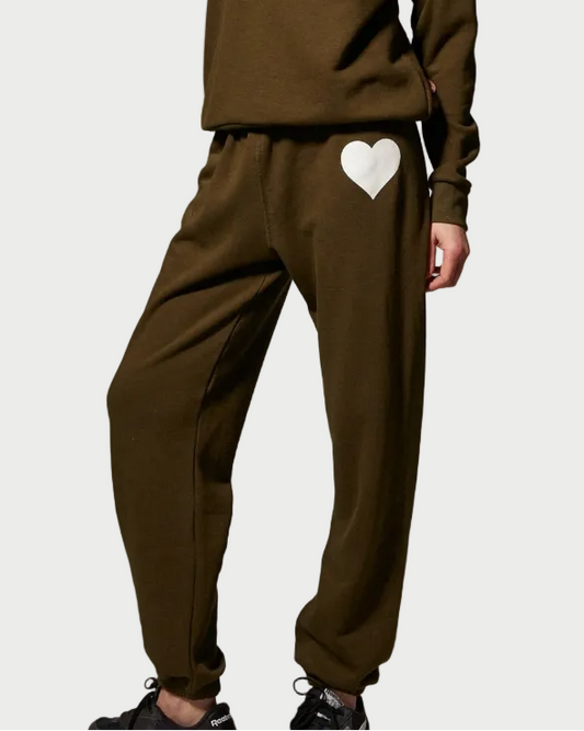 Olive green SPRWMN Heart Sweatpants featuring a large white heart graphic on the left hip.