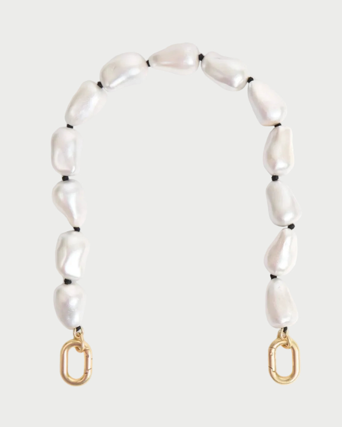 The CLARE V. Shortie Strap In Pearl is a decorative bag strap with irregular white pearls and black pearlized wood beads, finished with gold clasps at each end, shown against a plain light background.
