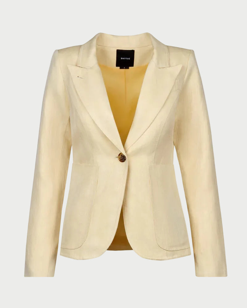 The Smythe Patch Pocket Duchess Blazer by Smythe is a women's light beige tailored blazer with a single-button closure, peaked lapels, leather elbow patches, long sleeves, and front pockets on a white background.