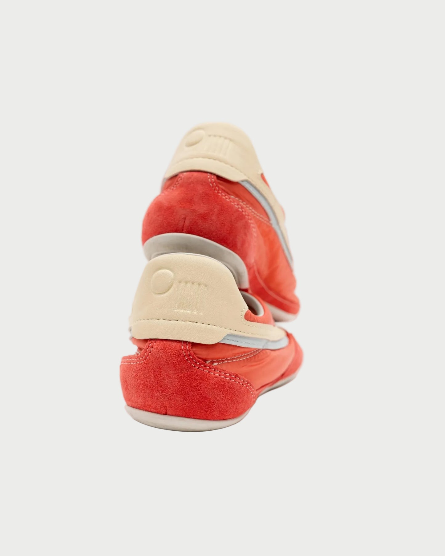 Red slip-on shoe with beige sole on a white background