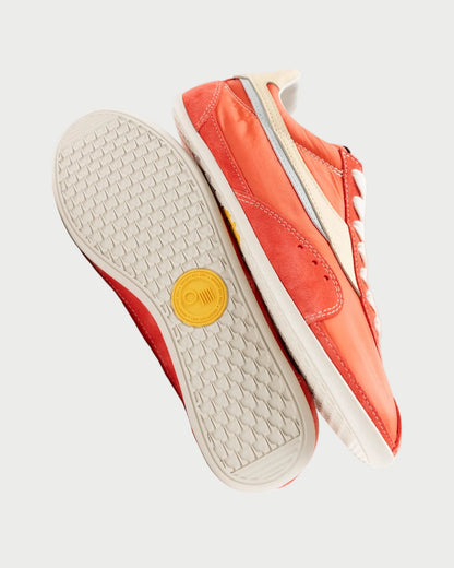 Orange sneaker with a yellow logo on a white background