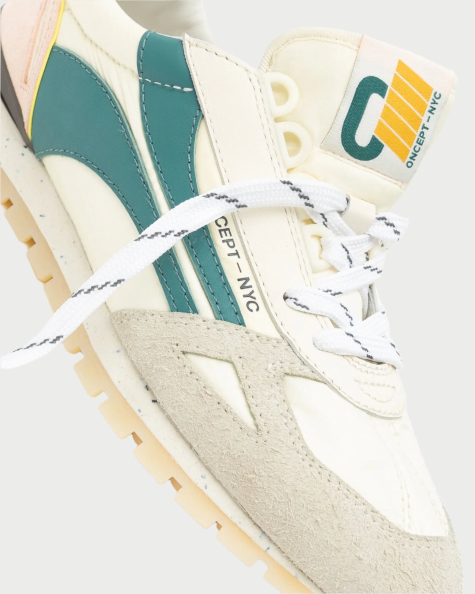 Close-up of the Toronto Sneaker by Oncept in cream and teal with suede accents, featuring sustainable design. It boasts a unique logo on the tongue, white laces with black detailing, and a light tan sole. The text "CONCEPT NYC" is visible on the side.