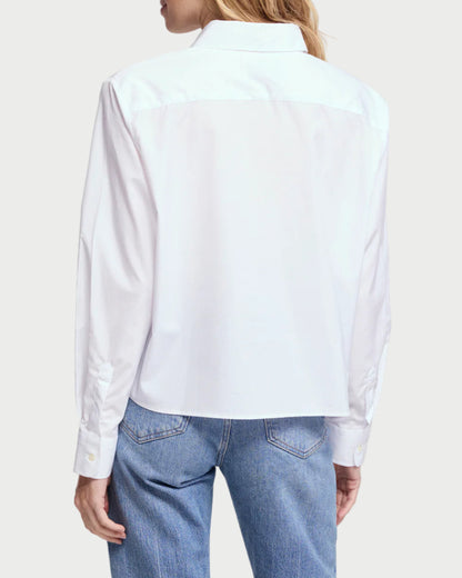 Woman wearing a light blue shirt and blue jeans on a plain background