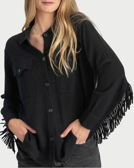 Woman wearing a black fringed jacket on a gray background