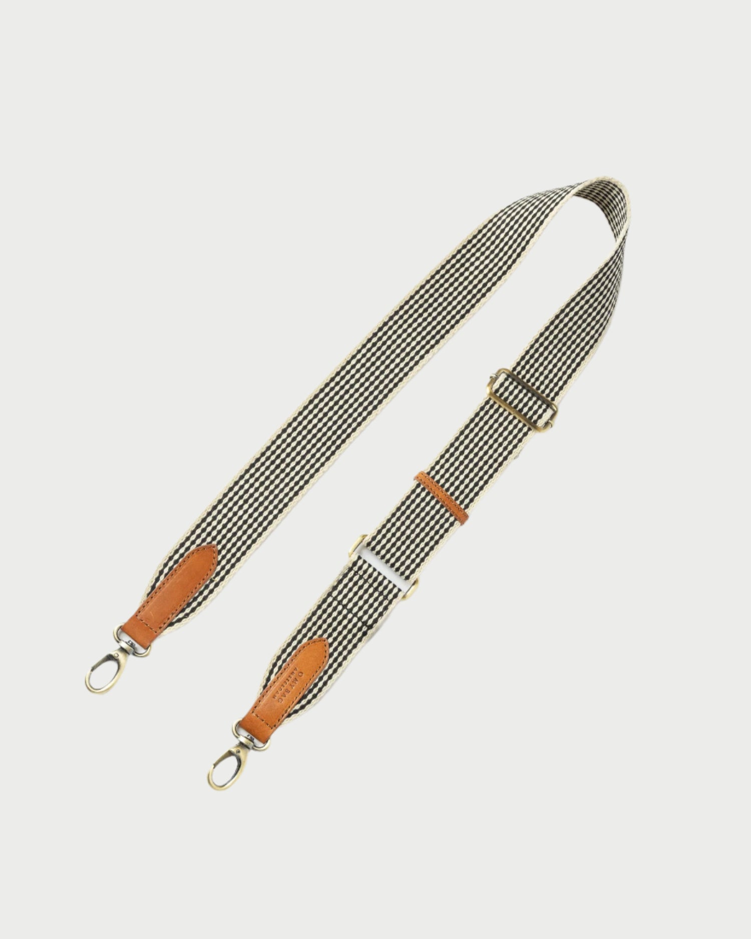 Fabric bag strap with leather accents on a white background