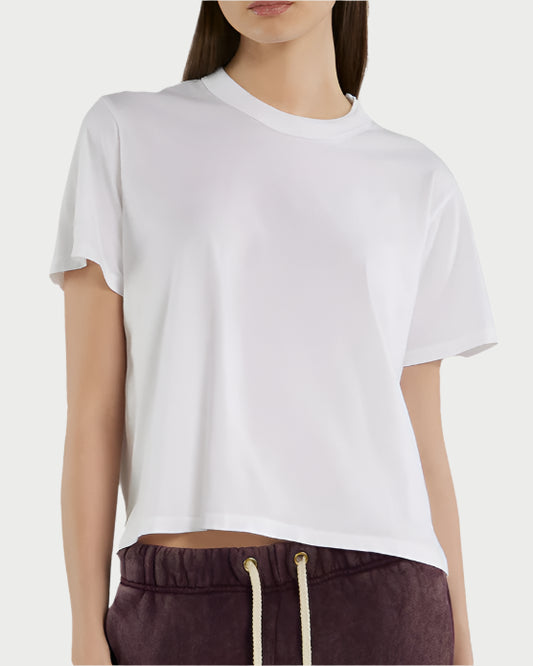Someone wears a relaxed fit Jane Classic Tee from Les Tien in plain white and maroon drawstring pants, shown from shoulders to hips against a light background.